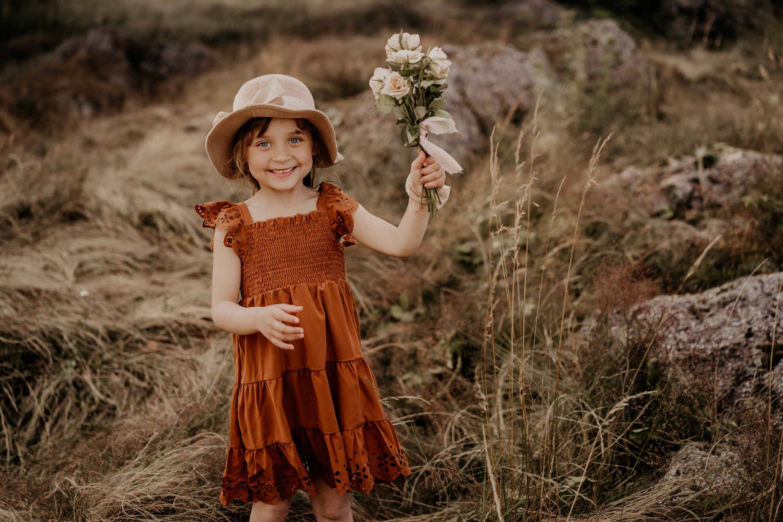 Fröhliches Mädchen mit Blumenstrauß bei einem natürlichen Familienshooting in Osnabrück. Perfekte Outdoor-Kulisse für emotionale Kinder- und Familienfotos.