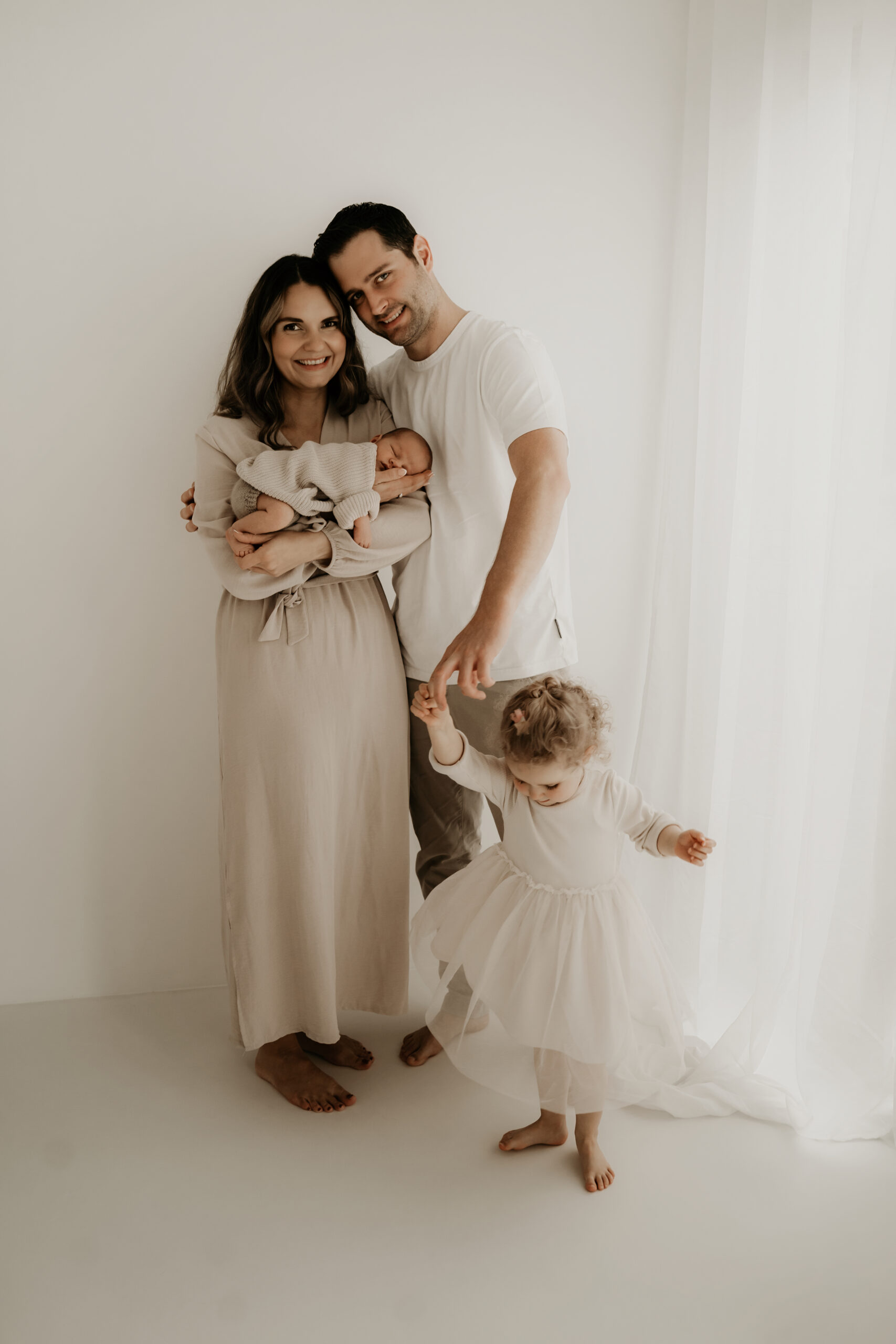 Eltern halten ihr Baby gemeinsam beim Studiofotoshooting