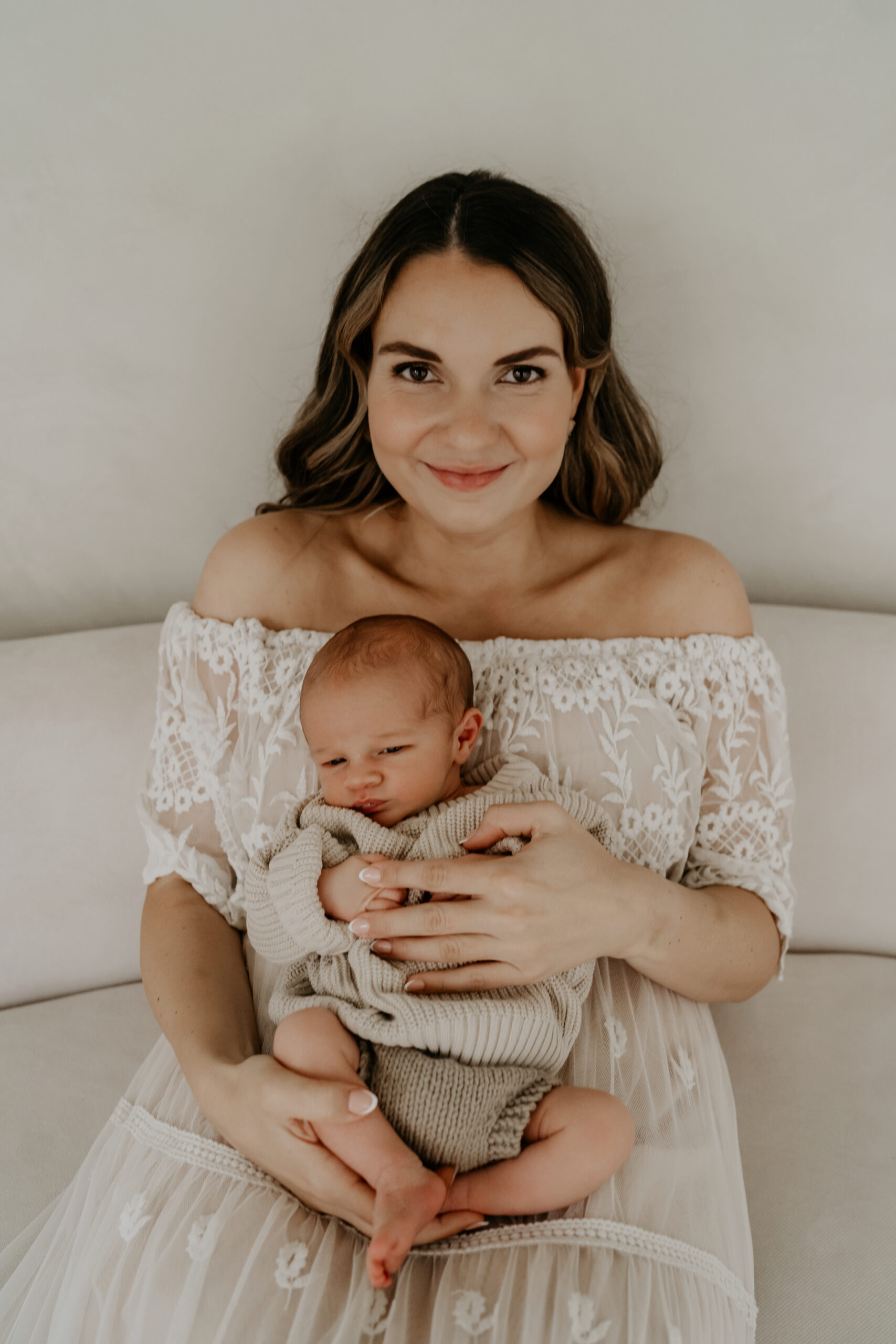 Mama hält sein Baby beschützend in den Armen – minimalistisch und voller Gefühl.