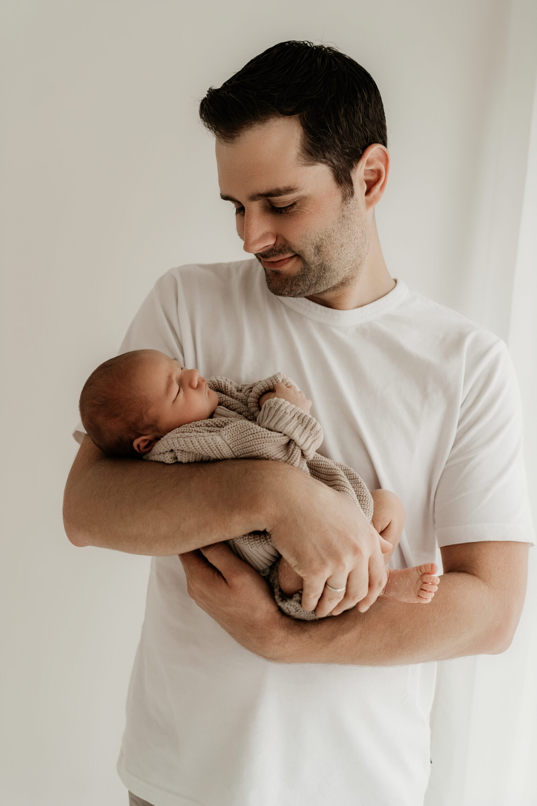 Vater hält Neugeborenes beim Fotoshooting in Lengerich