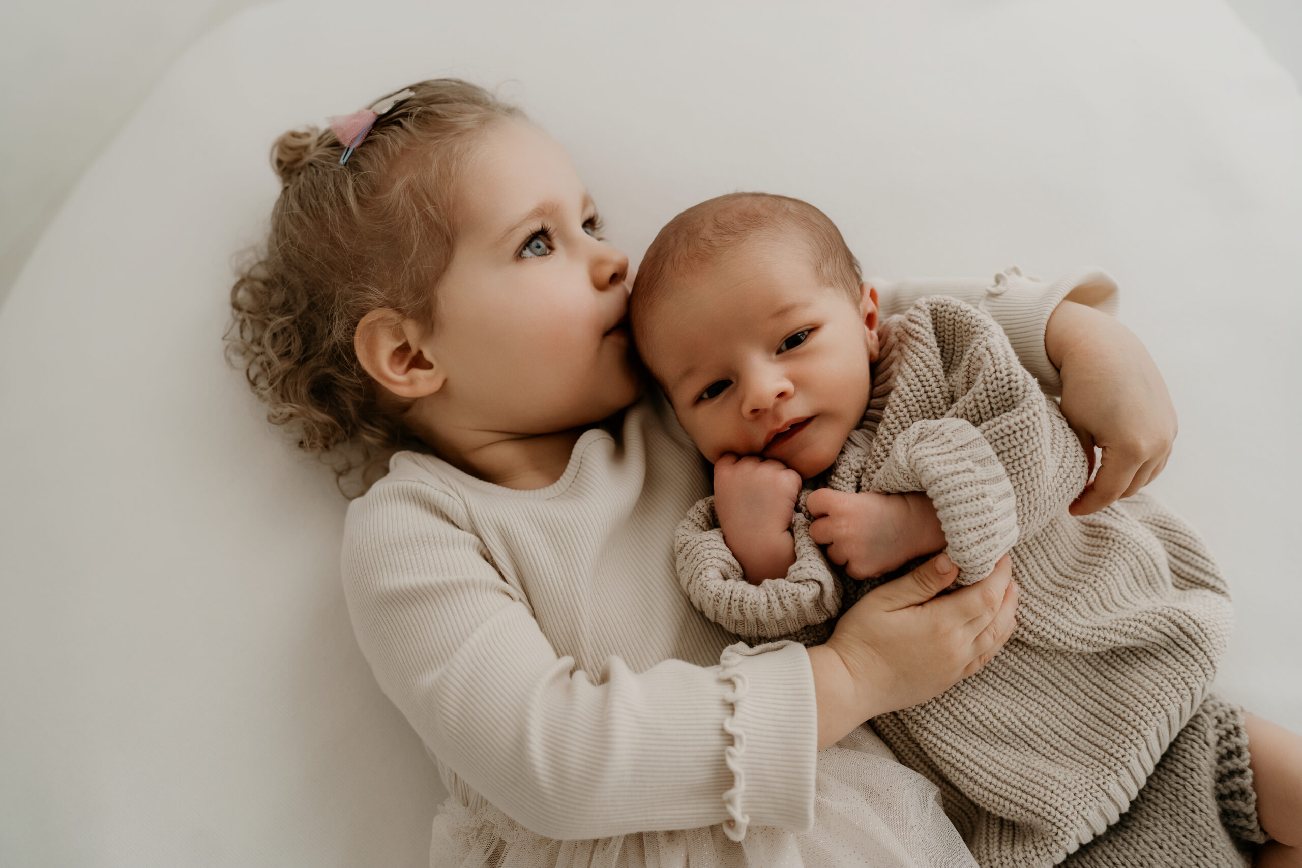 Innige Geschwisterliebe in zarten Farben. Emotionale Familienfotos im minimalistischen Stil