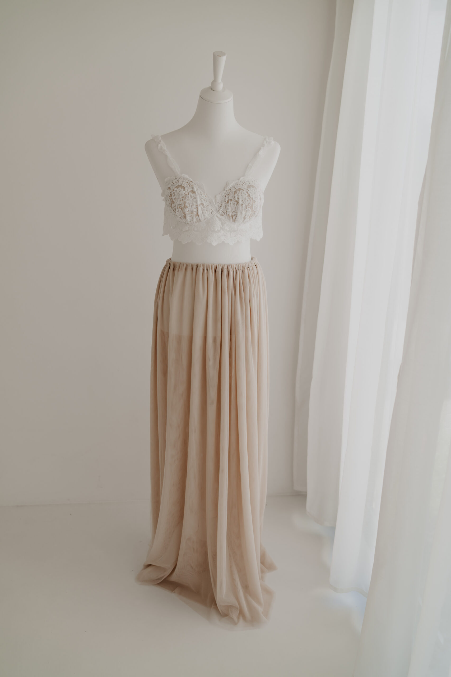 Zweiteiliges Babybauch Outfit mit Spitzenoberteil und fließendem Rock in Beige für natürliche Schwangerschaftsfotos