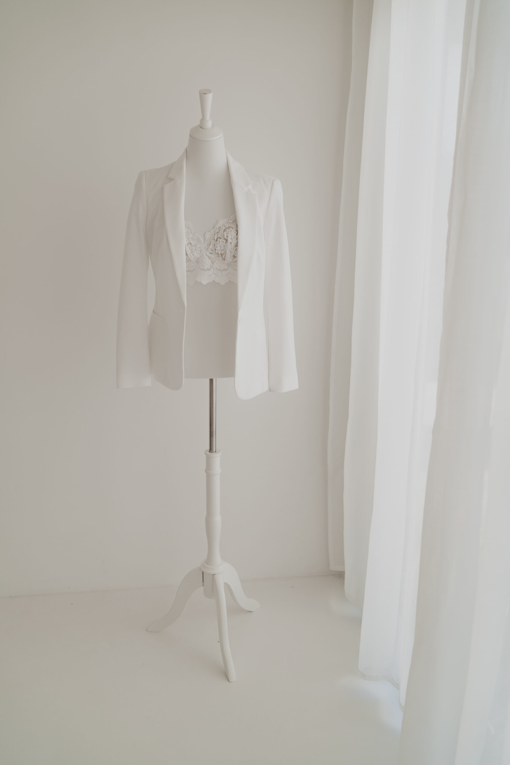 Modernes Babybauch Outfit mit weißem Blazer und Spitzenoberteil für stilvolle Schwangerschaftsfotos