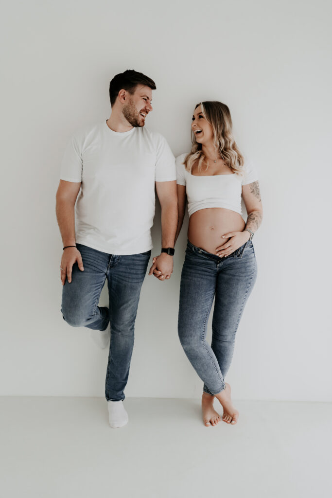 Glückliches Paar beim natürlichen Babybauchshooting in meinem hellen Studio in Osnabrück.