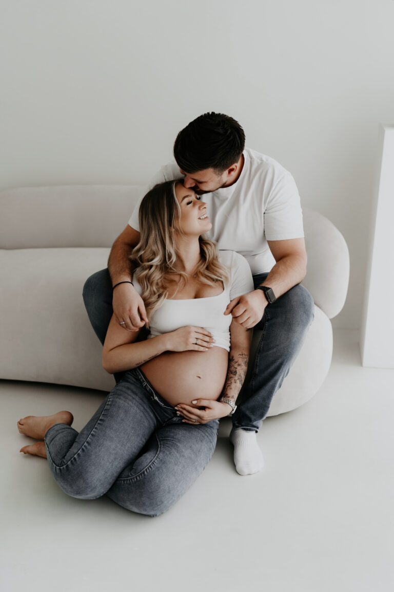 Liebevoller Moment zwischen werdenden Eltern während eines Babybauchshootings im Studio in Osnabrück.