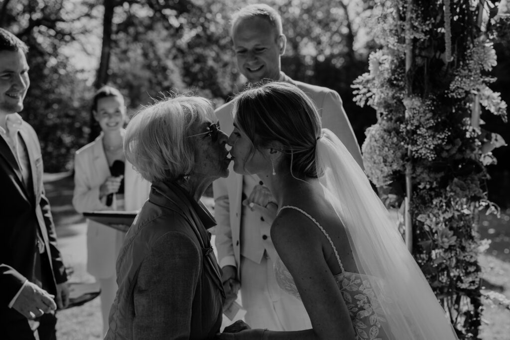 Die Braut küsst ihre Oma nach einer emotionalen Überraschung bei der Trauung
