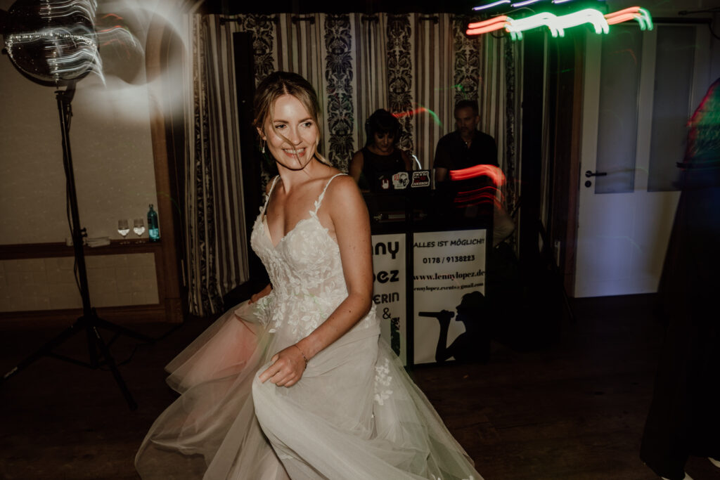 Braut beim Tanzen auf der Hochzeitsparty im Hof zur Linde
